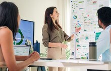 © Weedezign iStock Getty Images Plus Eine Frau zeigt auf eine Präsentation