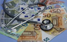 Symbolbild eines Stethoskop auf Geldscheinen