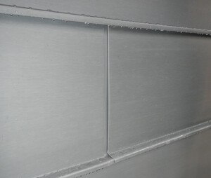 Längsstoß einer horizontalen Winkelstehfalzfassade mit unterlegtem Stoßblech und Hohlumschlag.