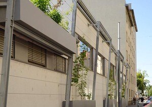 Aus Trögen beim Betriebsgebäude von Wien Kanal im 19. Bezirk Wiens wachsen Kletterpflanzen.
