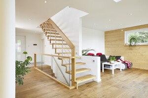 Die Stufen samt Holzdistanzen, die Handläufe und die Einfassung der Brüstung sind aus Holz. 