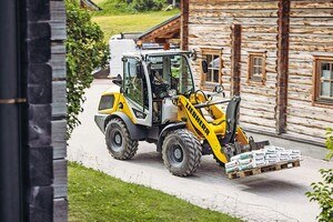 Für den sicheren Transport von Paletten mit Pflastersteinen oder Terrassenfliesen hat Liebherr die Parallelführung bei der neuen Kompaktlader-­Baureihe optimiert.