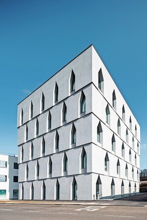 weißes, vierstöckiges Gebäude, blauer Himmel im Hintergrund