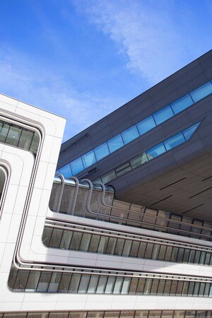 Beim Learning & Library Center der WU Wien sind ein weißer und ein schwarzer Baukörper ineinander verschränkt und durch eine gläserne Fuge optisch getrennt.