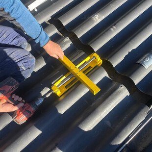 Vom Handwerker für Handwerker entwickelt: Mit dem "Wellenlöser" lassen sich Wellplatten zum Austausch ohne Mühe nach hinten schieben.