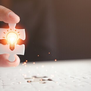 © WINEXA iStock GettyImages Plus Puzzleteil mit leuchtender Glühbirne