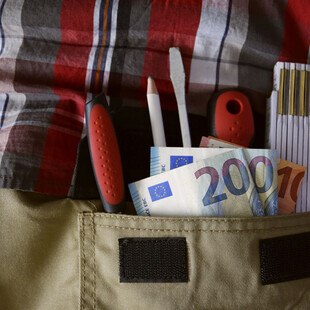 Geld und ein Zollstock in einer Hosentasche