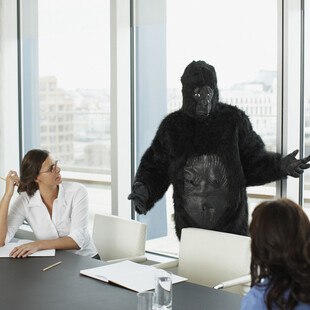 © Paul Bradbury iStock Getty Images Plus Eine Person in einem Gorillakostüm in einem Meeting