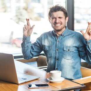 Mann kreuzt die Finger