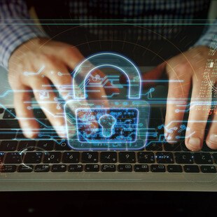 © Arkadiusz Warguła iStock / Getty Images Plus Cybersecurity Symbol und Hände auf Tastatur