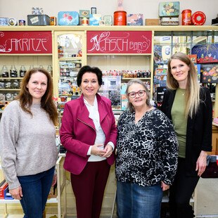 © Max Slovencik vier Personen in einem Geschäft