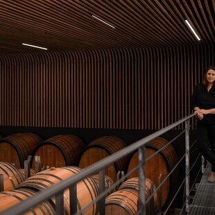 © Wine & Partners Albert Gesellmann steht gemeinsam mit Silvia Gesellmann vor Weinfässern.